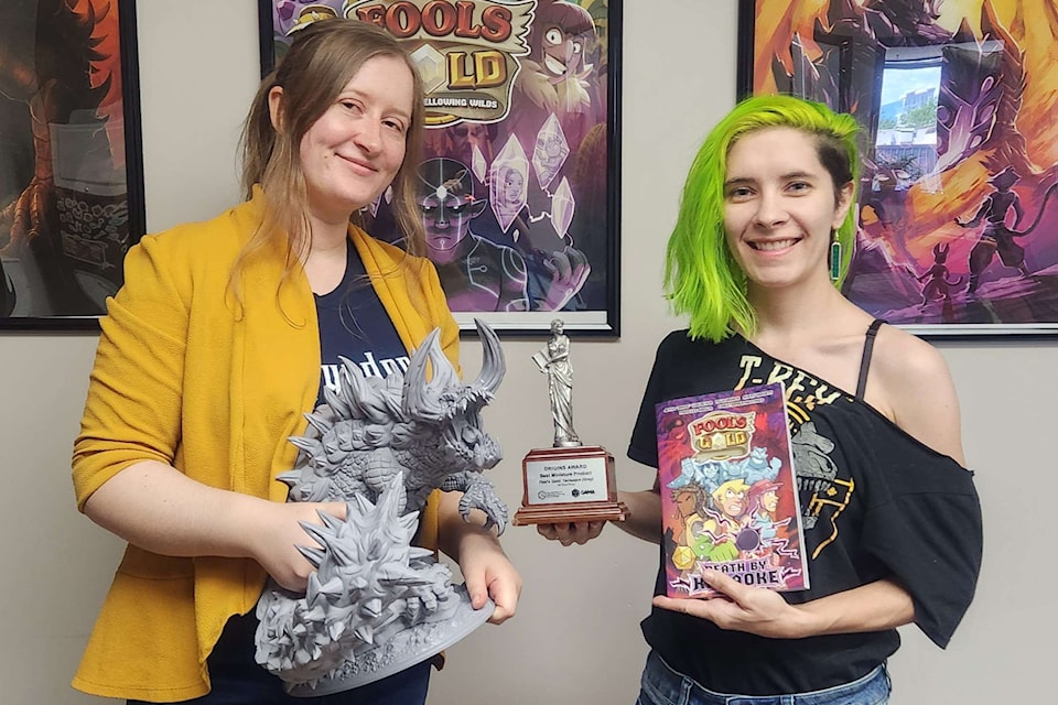 Jenna Woldenga, left, and Avery Howett show an award they received for their miniature at the Origins Awards 2025. They are among the creators of Fool㽶Ƶֱs Gold. The first book in the series, Fool's Gold: Death by Karaoke, will be released on July 25.