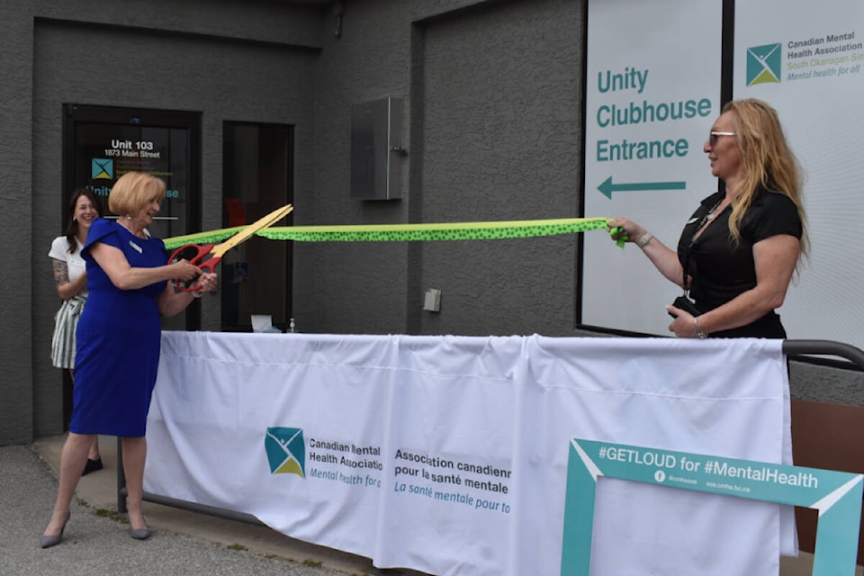 Canadian Mental Health Association of the South Okanagan Similkameen president Colleen Caron cuts the ribbon for the grand re-opening of Unity House on Penticton’s Main Street. (Brennan Phillips - Western News)