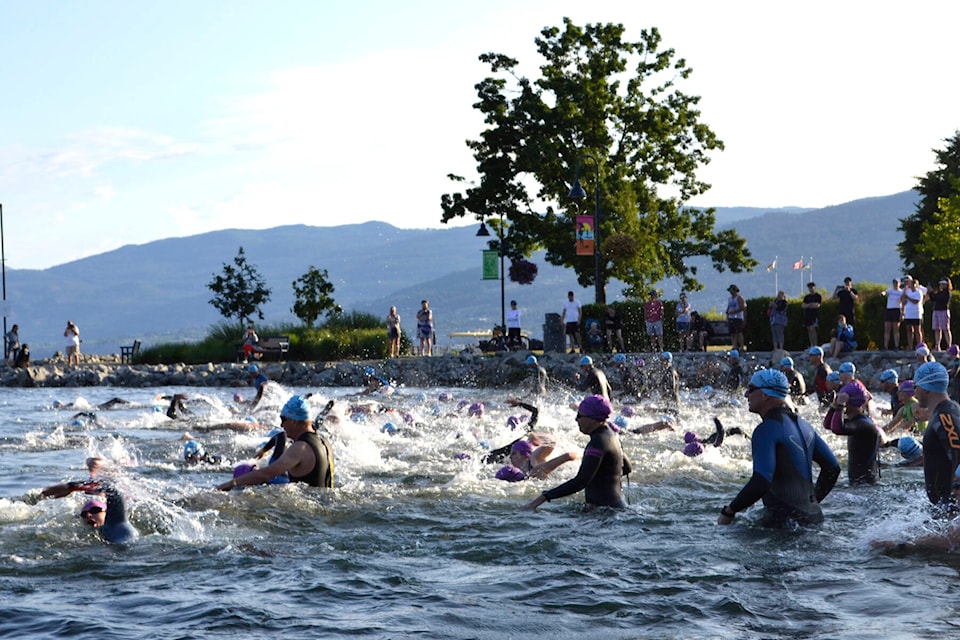 Peach Classic triathletes dive into Okanagan Lake in Penticton for the swim portion of the race on Sunday morning. (Monique Tamminga Western News)