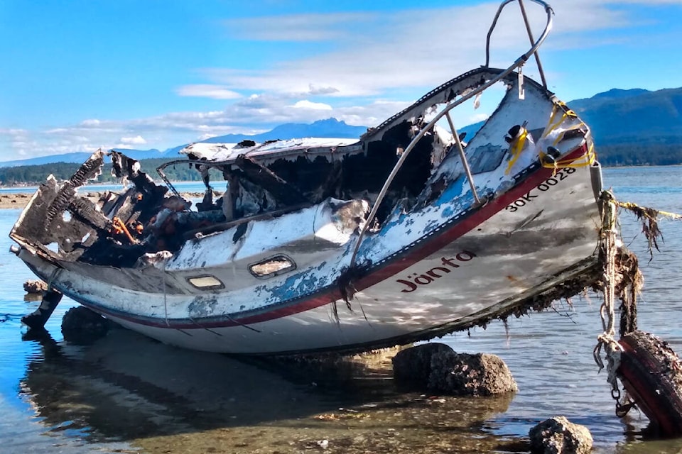 On July 16, a derelict boat washed ashore on Denman Island’s beachline and burst into flames a few hours later. As of Aug. 13, a little less than a month after the incident, the burnt wreck remains untouched. Photo courtesy of David Innes