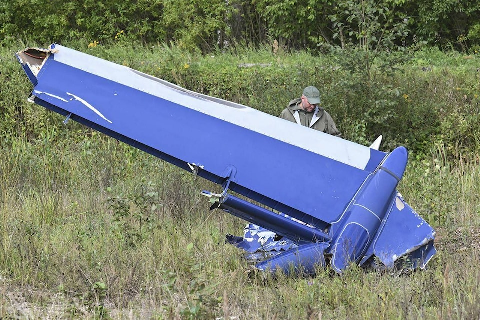 A Russian serviceman inspects a part of a crashed private jet near the village of Kuzhenkino, Tver region, Russia, Thursday, Aug. 24, 2023. Russian mercenary leader Yevgeny V. Prigozhin, the founder of the Wagner Group, reportedly died when a private jet he was said to be on crashed on Aug. 23, 2023, killing all 10 people on board. (AP Photo)