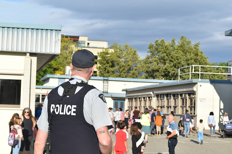Kelowna RCMP Media Relations Officer patrols in front of Raymer Elementary School as kids return to class on Tuesday, Sept. 5. (Jordy Cunningham/Capital News)