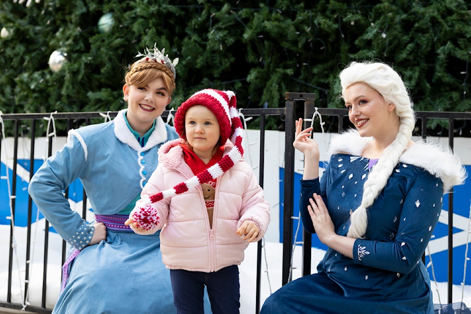 Bella Hamon, 2, posed for a photo with Anna and Elsa from Frozen at the Surrey Tree Lighting Festival in Civic Plaza in Surrey on Saturday, Nov. 23, 2024. 