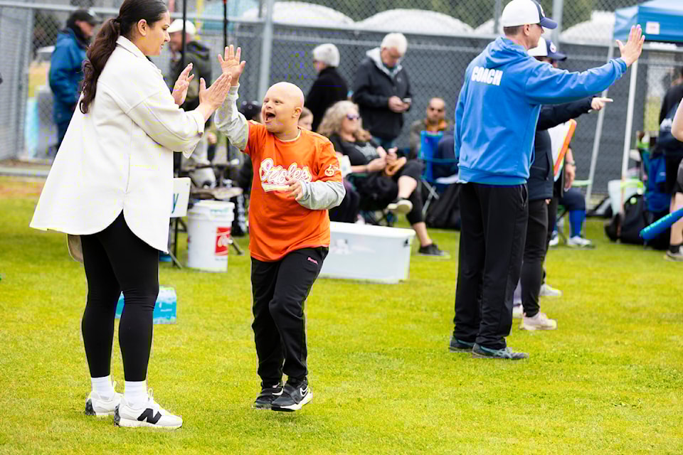 A player from the Abbotsford Orioles giving someone in the crowd a high five after passing home plate at the Challenger Jamboree at South Surrey Athletic Park in Surrey on Saturday (June 21).  