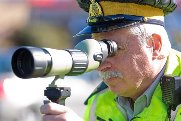 Sgt Gary Clarke peers down the road through a scope.