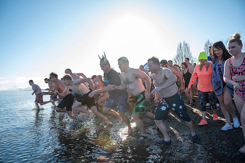 Records were broken as more than 500 raced towards the cold waters of Boundary Bay for the 40th annual Polar Bear Swim at Centennial Beach in Delta, B.C. on Jan. 1, 2020. “There were so many people we actually ran out of Polar Bear buttons, way more than 500 participants this year,” said event volunteer Britta Forbes. (Ryan-Alexander McLeod photo)