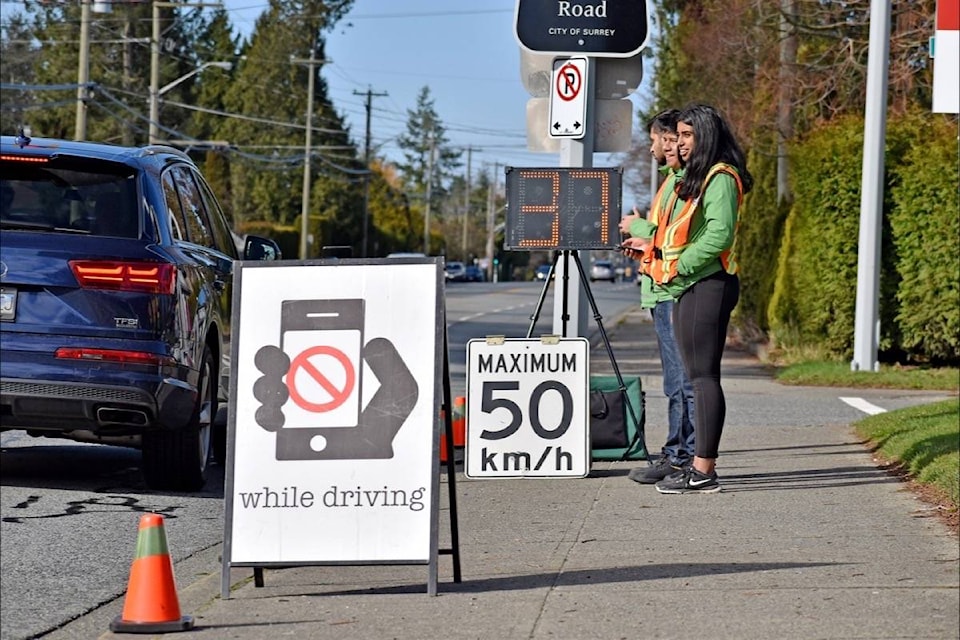 Cell Watch volunteers were stationed along 16 Avenue/North Bluff Road Friday morning, including at 146 Street, where Raveena Basra, Jose Cardenas and Tanvir Gakhal were part of a prominent reminder to drivers to put their phones down. (Tracy Holmes photo)