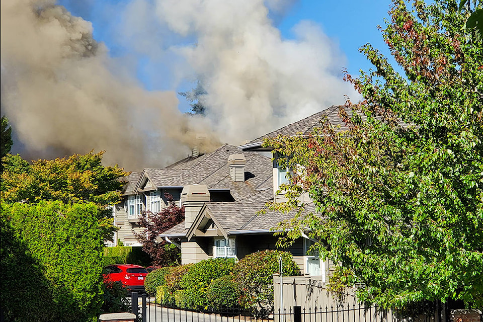 Smoke billows from the roof of a townhouse in South Surrey. (Colin Simpson photo)