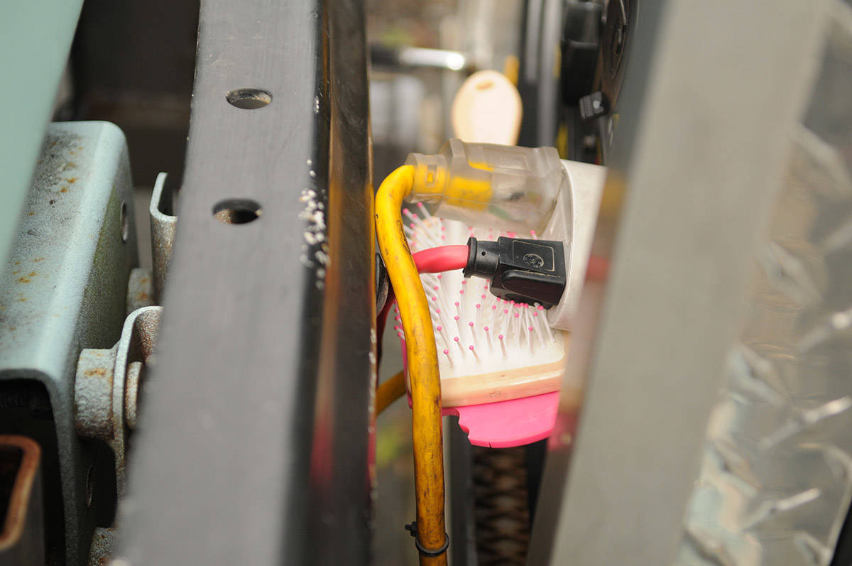 A hairbrush is wedged underneath plugs outside the generator of Prime Real Estate Salon to prevent them from jostling loose while the machine is running. (Jenna Hauck/ Chilliwack Progress)