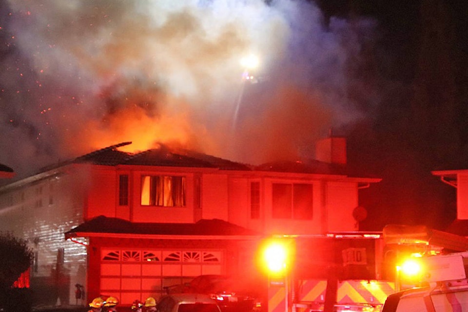 Surrey firefighters battle a house fire near the 70A Avenue and 126A Street intersection early Sunday morning. According to a witness, it appears that the occupants were able to get out without injury. (Shane MacKichan photos)