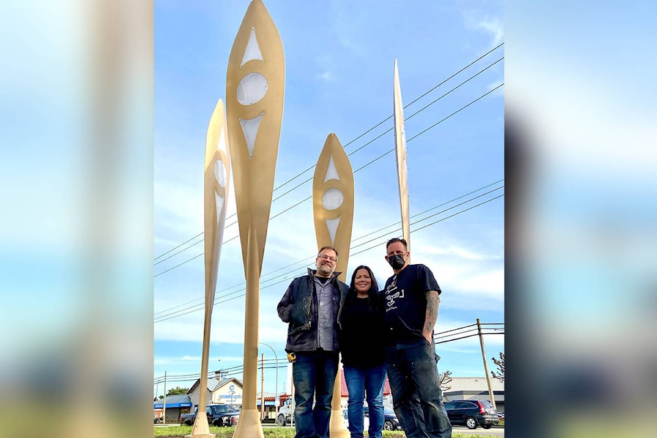 Artists (from left) Aaron Jordan, Phyllis Atkins, and Drew Atkins stand in front of their new sculpture “The Rivers that Connect Us” at the Museum of Surrey. (Image via Facebook)