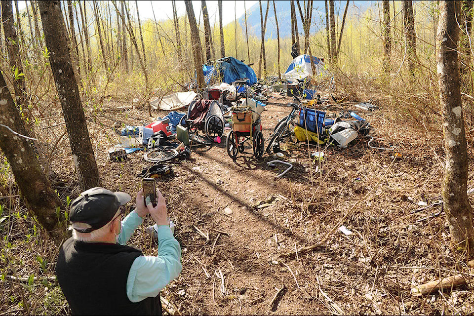 Terry Bodman snaps a photo on April 15, 2021 of one of the two active homeless camps on Soowahlie First Nation land. (Jenna Hauck/ Chilliwack Progress file)