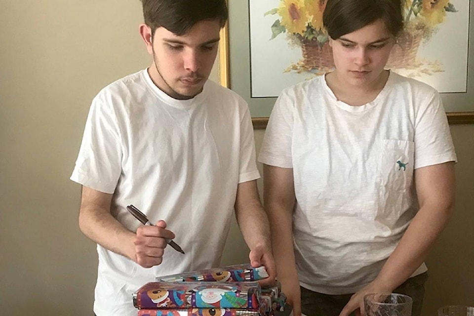 Noah and Alesha wrap shoeboxes for youth in Zimbabwe. (Contributed photo)