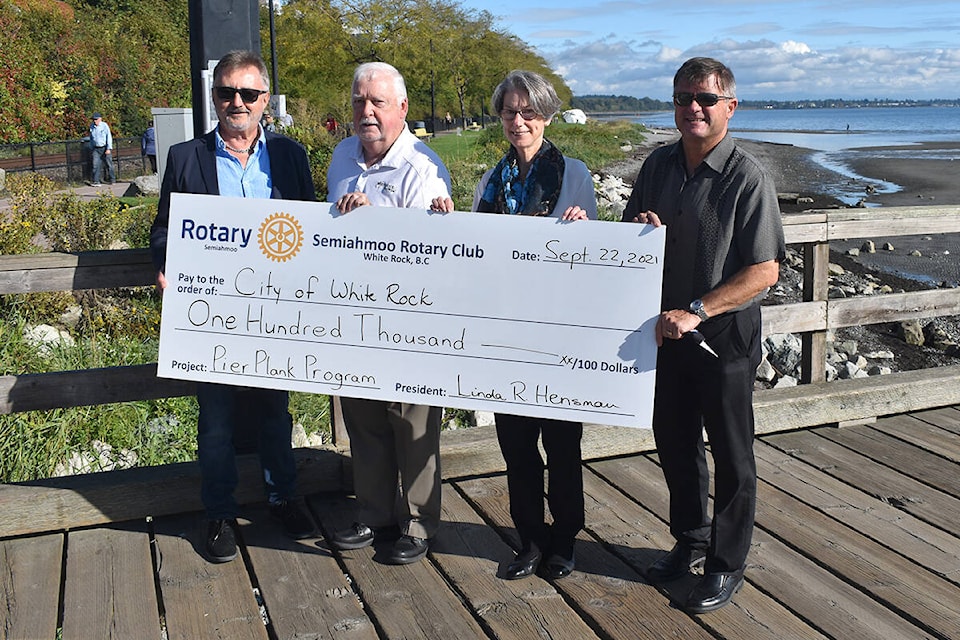 Friends of the Pier members Bob Bezubiak (left), Linda Hensman (second from right) and Stewart Peddemors (right) present White Rock Mayor Darryl Walker (second from left) with a cheque for $100,000 to help fund future improvements for the White Rock Pier. (Nick Greenizan photo)