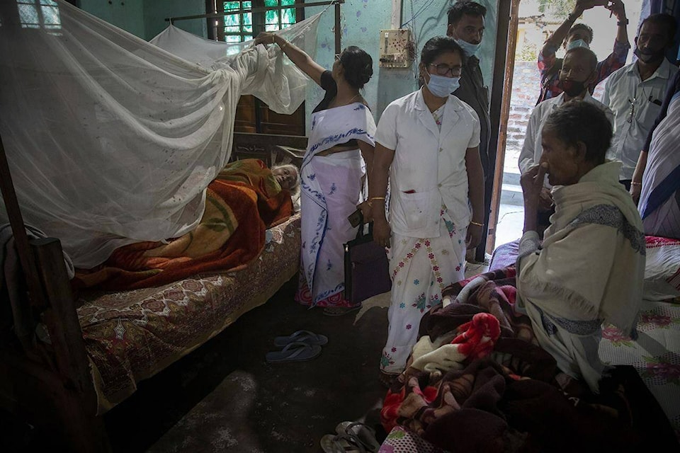 Health workers try to convince elderly people to receive the vaccine for COVID-19 during a door-to-door vaccination drive in Ouguri village, on the outskirts of Gauhati, India, Tuesday, Nov. 30, 2021. From South African undertakers to ultra-Orthodox Israeli rabbis, an unconventional cadre of people has joined global efforts to increase COVID-19 vaccination rates. Launching campaigns that traditionally have been the realm of public health authorities, they’re opening church doors, going door to door, village to village, touting the benefits of vaccination, sometimes making shots available on the spot. (AP Photo/Anupam Nath)