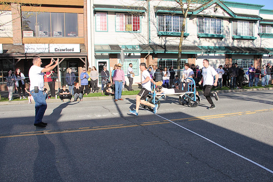 The Turkey’s Party Makers Racing Team crosses the finish line to win the 2022 Bed Pan trophy at the Cloverdale Bed Races May 19. Turkey (left) instructs the team to pull up as they crossed the line with an enormous lead. (Photo: Malin Jordan)