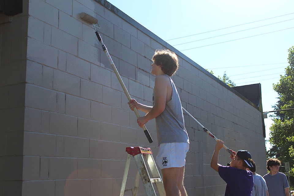 Tristan Kristol (on the ladder) and Keegan Sheridan participated in painting over graffiti at Ocean Park Pizza and Village Pub. (Sobia Moman photo)