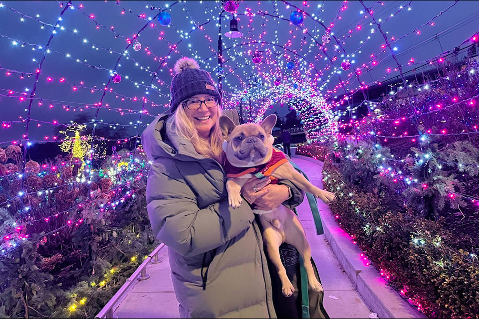 Julia Phillips and her French bulldog, Theo, pose for a photo in the light tunnel at Bright Walk in White Rock. (Tricia Weel photo)