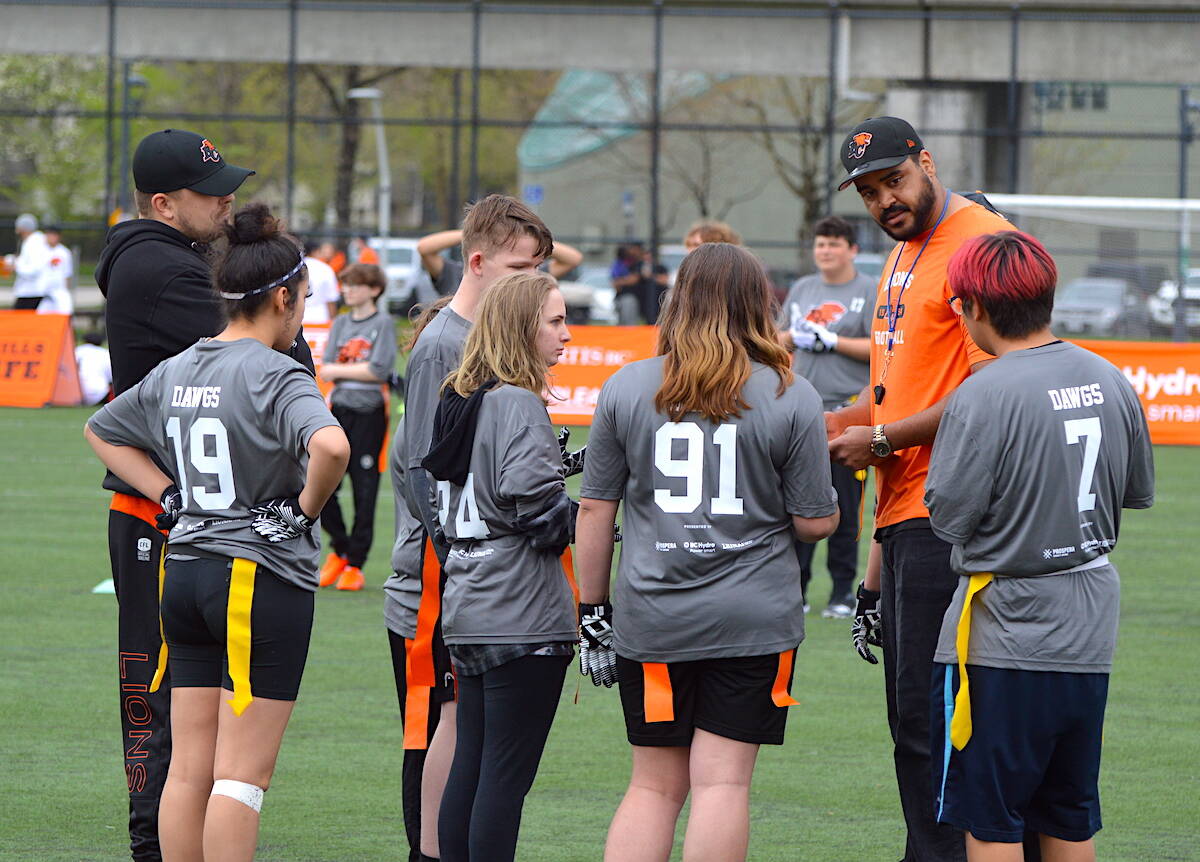 BC Lions player David Knevel coaches Surrey Dawgs team members during the CFL teams Indigenous Youth flag football tournament at Tom Binnie Park in Surrey on Sunday, April 30, 2023. (Photo: Tom Zillich)