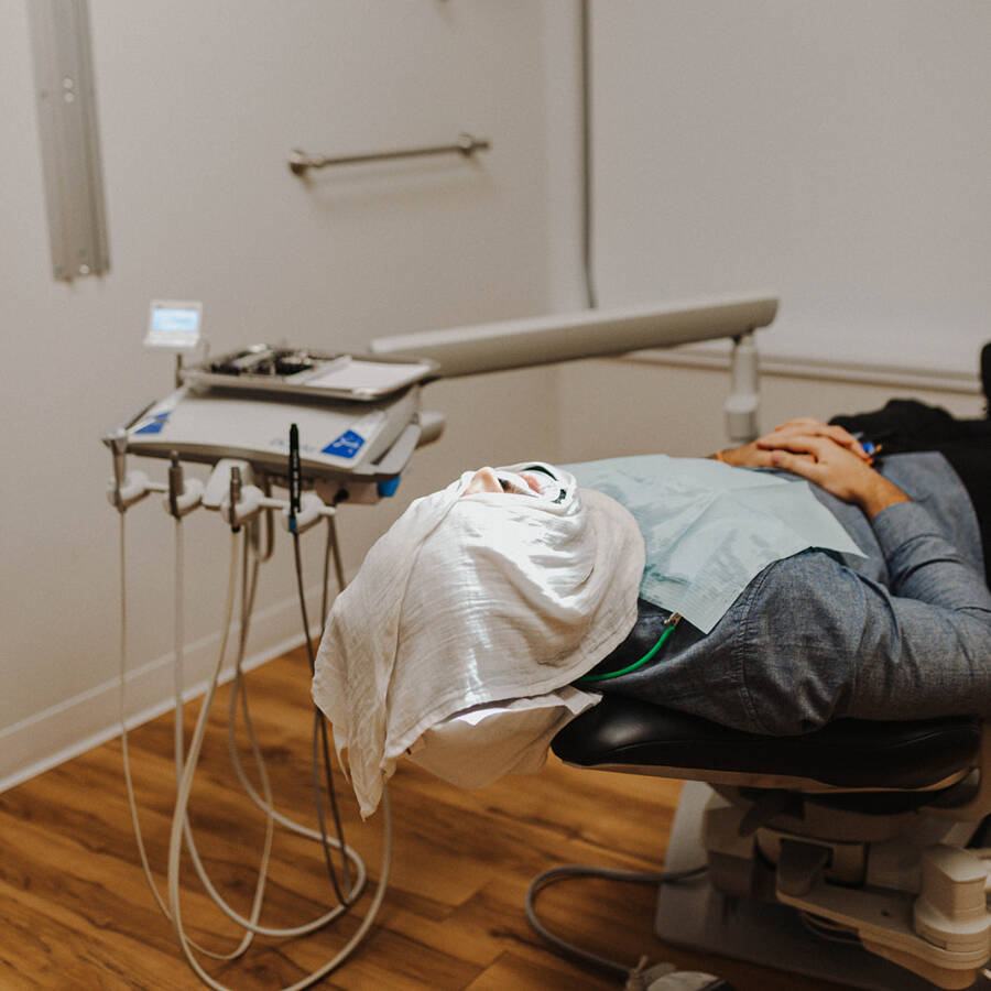 A patient enjoying hot towel service at Dental Zone.