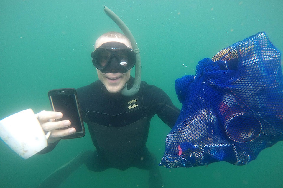 Steve Clegg holds some of the items he found at the bottom of Cultus Lake on Friday, June 16, 2023. (Jenna Hauck/ Chilliwack Progress)