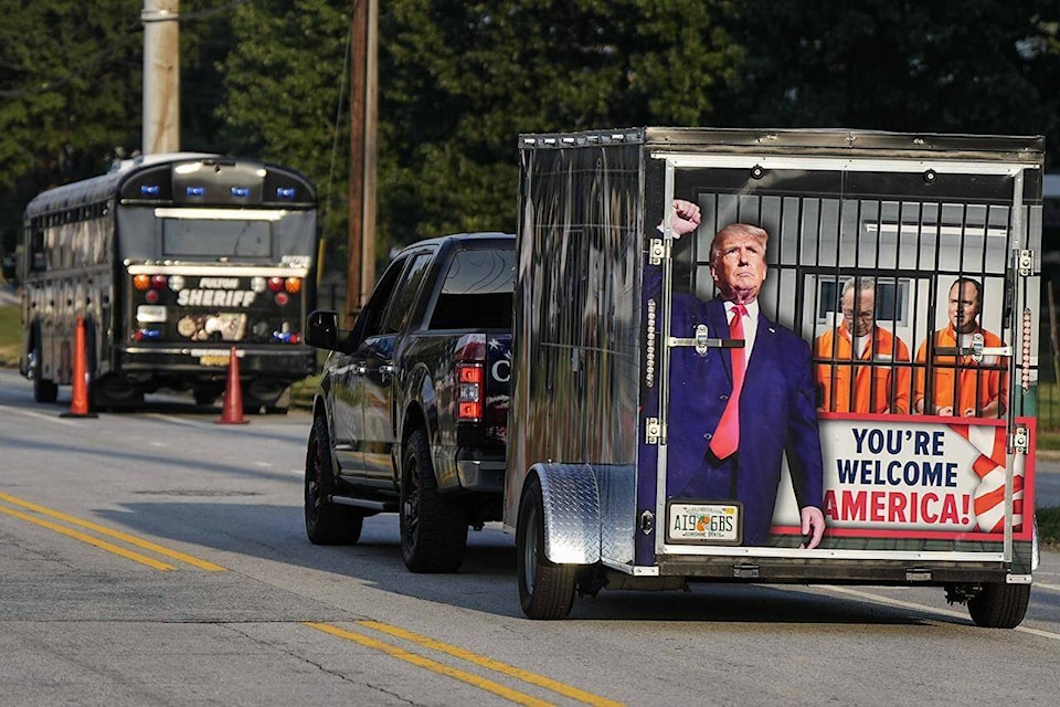 A vehicle and trailer drive by the Fulton County Jail, Thursday, Aug. 24, 2023, in Atlanta. Trump is charged alongside others, who are accused by Fulton County District Attorney Fani Willis of scheming to subvert the will of Georgia voters to keep the Republican president in the White House after he lost to Democrat Joe Biden. (AP Photo/Mike Stewart)