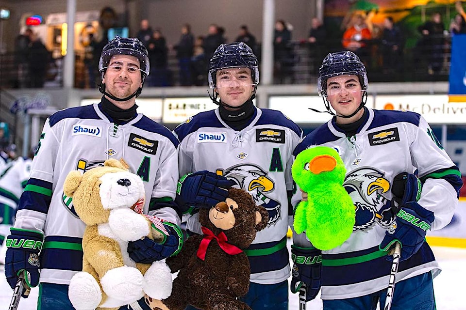 Surrey Eagles players with teddy bears on the ice during the junior hockey team's annual "toss" game in 2023 at South Surrey Arena.