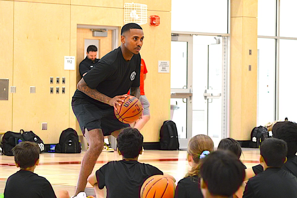 Const. Taylor Browne of Surrey Police Service demonstrates shooting at a SPS-hosted basketball camp for kids at Holy Cross Regional High School in Surrey on Thursday, July 31, 2025.