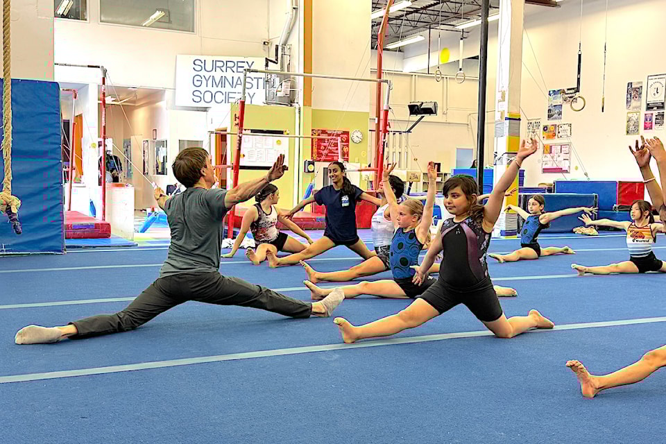 Coach Henry Condor leads young gymnasts through stretching exercises at Surrey Gymnastic Society's facility in Newton on Thursday, May 8, 2025.