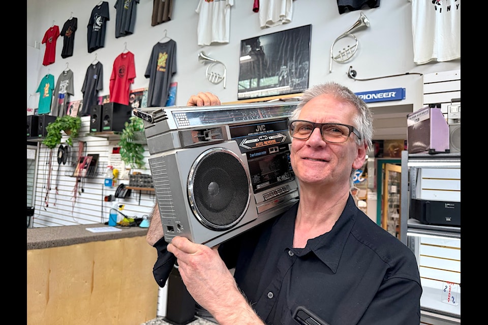 Mark Smith holds a "ghetto blaster" to his ear at the Innovative Audio store in Surrey on May 8, 2025.