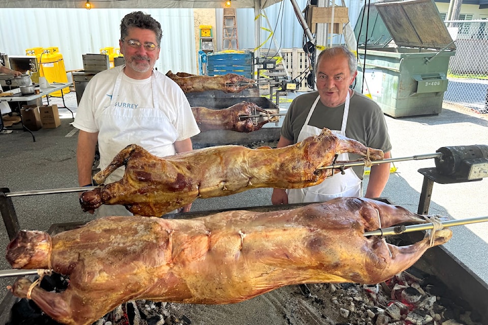 Food co-managers Ron McKave, left, and Tony Ziskos with roasted lamb cooking on spits at Surrey Greek Food Festival on Friday, June 6, 2025.