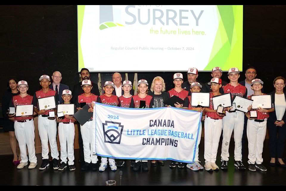 Players with Whalley Little League Major All-stars team with banner in Surrey Council chambers on Monday, Oct. 7, 2024.