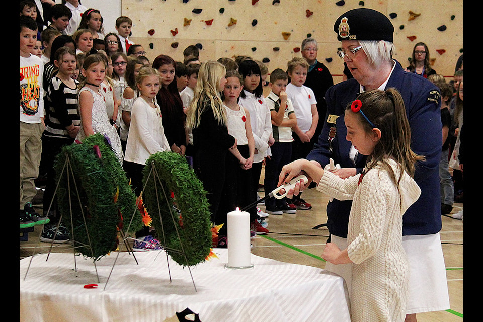Wendleynn McCutcheon of the Sylvan Lake Legion and her granddaughter Kayliegh McCutcheon light the candle during C.P. Blakey Elementary School’s Remembrance Day ceremony the morning of Nov. 7. Photo by Kaylyn Whibbs/Sylvan Lake News