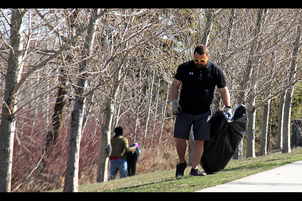 Mayor Sean McIntyre carefully inspects the area around sidewalks on the east edge of Centennial Park looking for any stray pieces of litter.