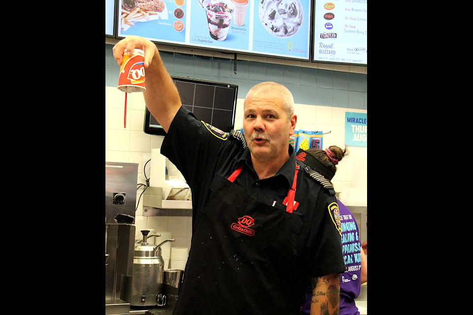 Sylvan Lake Fire Chief Cliff Brausen proudly shows off the DQ Blizzard he made during the annual Miracle Treat Day on Aug. 8. Members of the Sylvan Lake Fire Department have been a part of the annual event nearly every year since it began in Sylvan Lake. Photo by Megan Roth/Sylvan Lake News