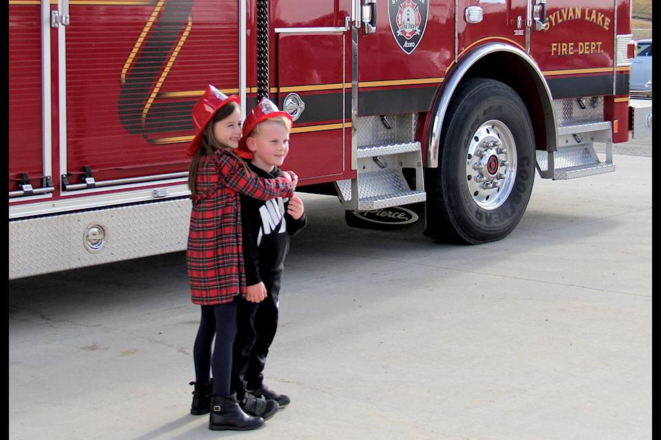 Georgia (left) and Luca Johner pose for a sibling picture infront of one of Sylvan Lake Fire Department’s trucks at their annual Fire Hall Open House on Oct. 19. Photo by Kaylyn Whibbs/Sylvan Lake News