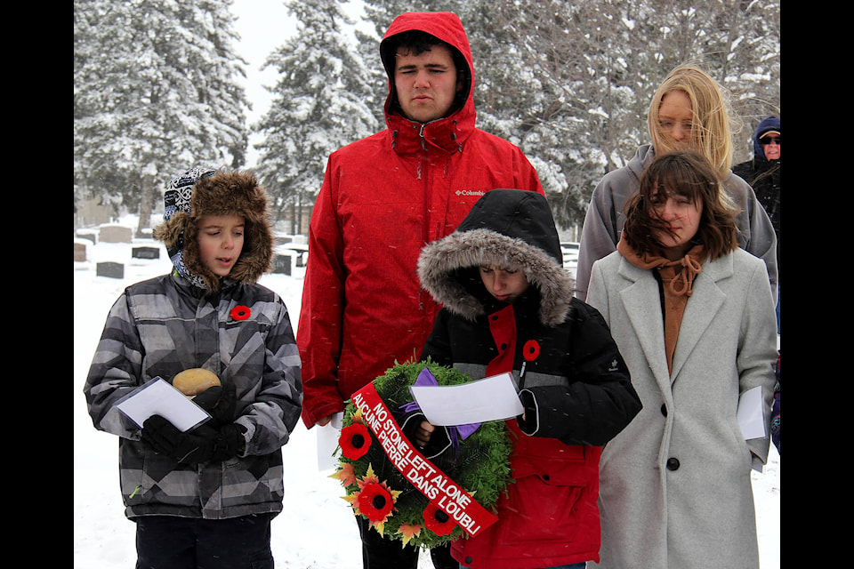 Students in the Ment to Matter program from Ecole HJ Cody High School and CP Blakely Elementary School participated in the No Stone Left Alone ceremony at Lakeview Cemetery on Nov. 5. The students braved the cold, wind and snow to honour local veterans with a small ceremony and by laying a poppy at their graves. Photos by Megan Roth/Sylvan Lake News