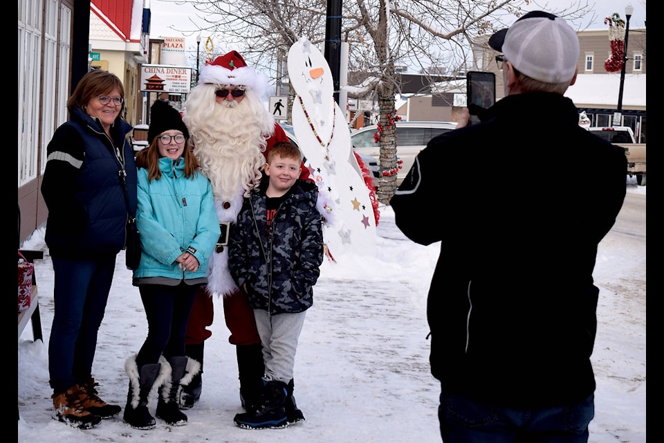 A family poses for a picture with Santa Claus on Centennial Street Dec. 14. Mr. Claus was strolling the street Saturday afternoon as part of the Town’s Handmade + local holiday event taking place along 50 Street and at the NexSource Centre. Photo by Kaylyn Whibbs/Sylvan Lake News