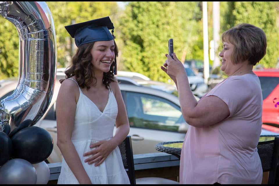 An Notre Dame High School graduate laughs through a photoshoot with a family member at Bukz on June 4. The event had Sylvan Lake graduates from H.J. Cody, Notre Dame, St. Joe’s, Hunting Hills and Lindsay Thurber. Photo by Deb McNeil Photography/Submitted.