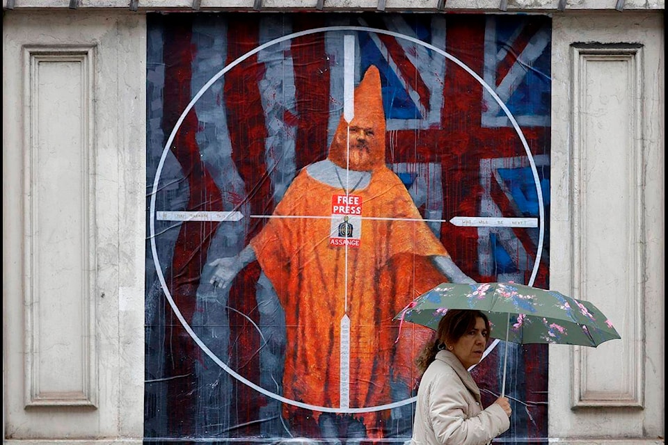 FILE - In this Monday Oct. 21, 2019 file photo a pedestrian passes street art depicting Julian Assange near Westminster Magistrates’ Court in London where Assange is expected to appear as he fights extradition to the United States on charges of conspiring to hack into a Pentagon computer, in London. (AP Photo/Kirsty Wigglesworth, File)