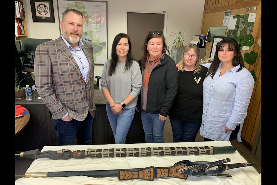 From left to right, Mayor Sean Bujtas, Marianne and Midori Nicolson of the Dzawada’enuxw Nation, and Nakkita Trimble and Kelli Louie of Coast Mountain College's Freda Diesing School of Northwest Coast Art, stand in front of the two Talking Sticks at Terrace City Hall. 