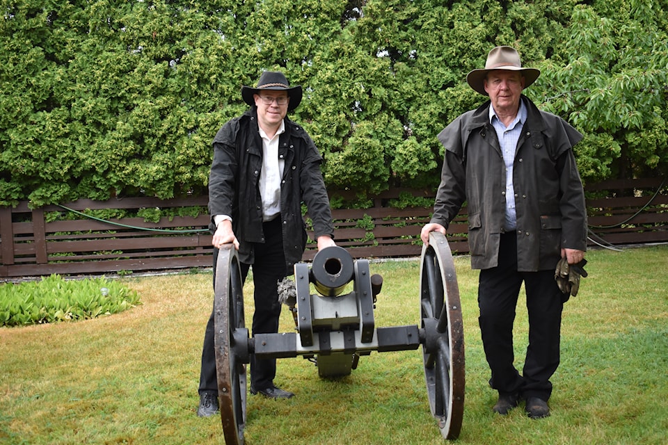 Paul Harrison and Ted Ramsey stand by the replica of 60s mountain howitzer cannon used during the inauguration of Riverboat days every year. 