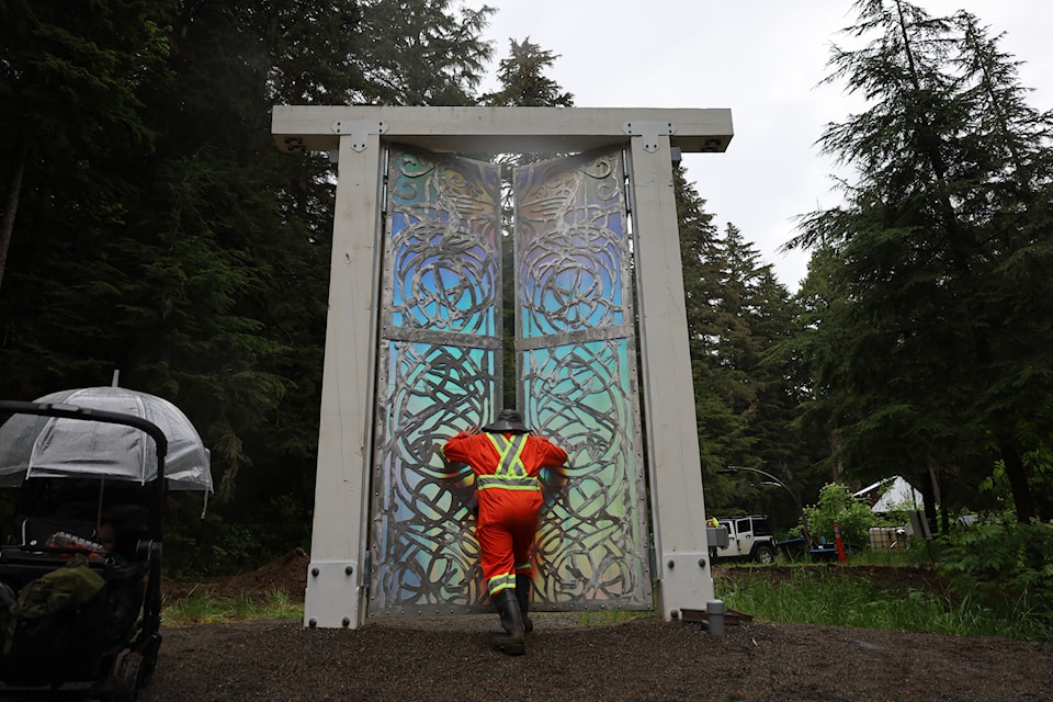 Jordie Laidlaw, director of art and operations, opens a holographic gate that serves as portal between the Asgard stage and the rest of the sites at the festival. To the left is Asher, Jordie and Erinn McPherson's son who is nearly 1 year old. It will be his second Valhalla Fest as he was in utero during last year's event.