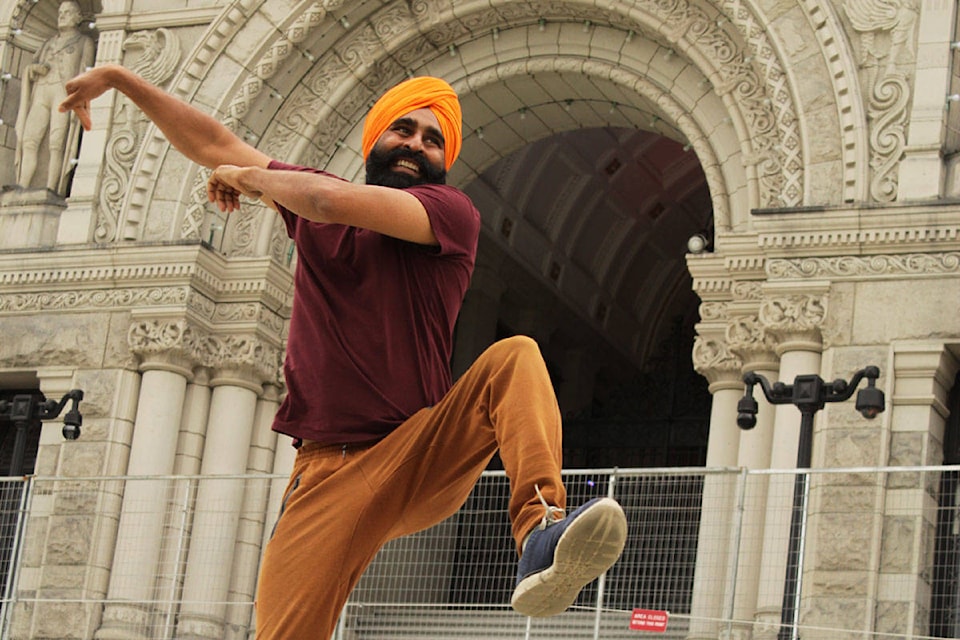 Gurdeep Pandher, a Yukon-based bhangra dancer, shows his skill with sweeping arm movements and high kicks on the steps of the BC Legislature Building on Saturday, Aug. 8, 2020. (Devon Bidal/News Staff)