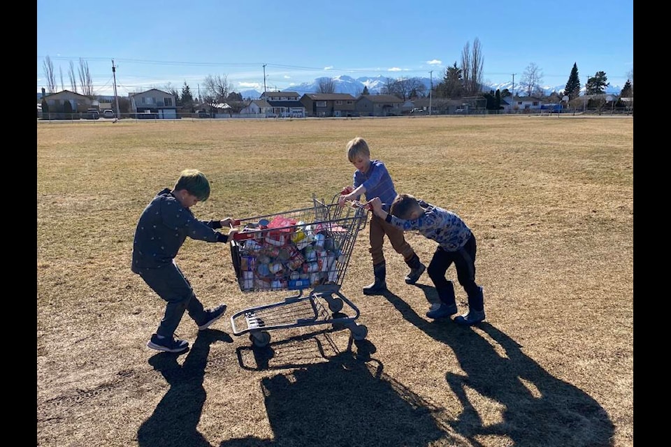 Centennial Christian School students Daxton, Carson and Keegan push a cart loaded with food towards its destination at the Terrace Church’s Food Bank on Kalum St. in Terrace. (Submitted photo/Kelsey Merritt)