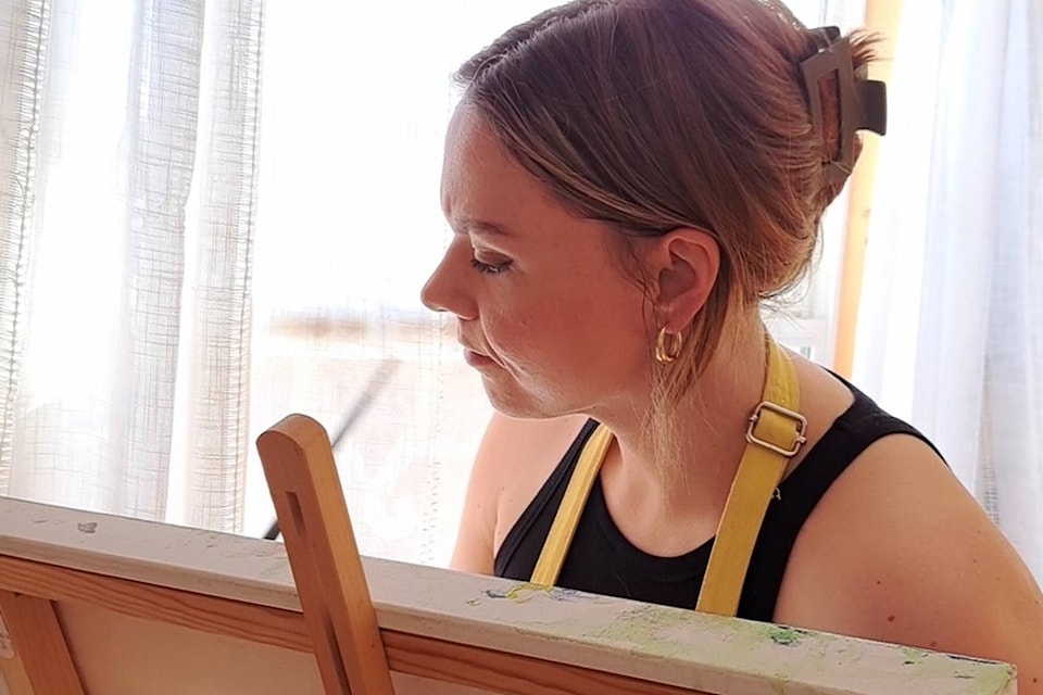 Katie Kmet, a featured artist at the Skeena Salmon Arts Show, immersed in her craft as she brings a new acrylic masterpiece to life. (Contributed photo)