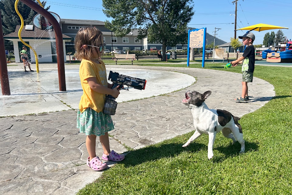 Marlee Rich shares some water with Ivy, the dog, on Tuesday, Aug. 26, 2025 at Kiwanis Spray Park in Williams Lake as the summer heat returned for the last week of summer holidays.