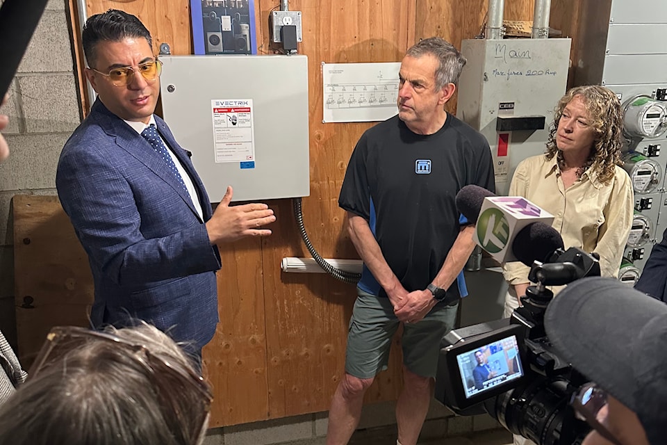 Kambiz Pishghadam Ghaeni of Evectrix explains the company's new smart panels to media and homeowners John Woakes and Alexa Cartwright in Vancouver on June 19, 2025.