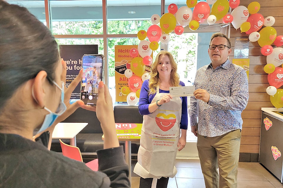 The first big donation of the McHappy Day on Wednesday, May 11 at the Langley Murrayville McDonald’s arrived with volunteer Lanette Salisbury, a Langley realtor who brought a $500 cheque from Homelife Benchmark Realty, then took charge of the prize wheel. (Dan Ferguson/Langley Advance Times)