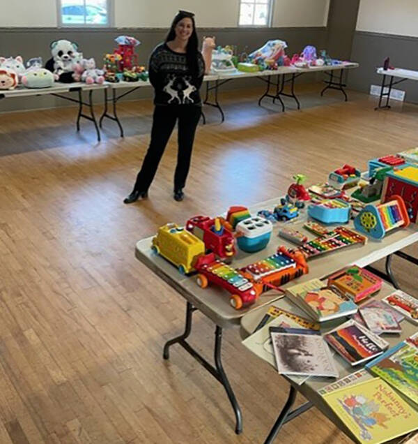 Kelsey Findlay stands with tables of toys for a Semiahmoo Peninsula toy exchange between residents for this holiday season. (Contributed photo)